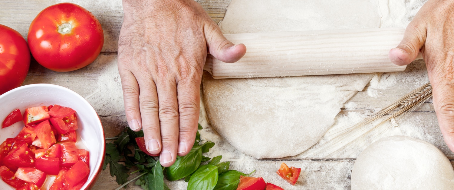 Productos sin gluten - Don Pizza Logistic Manos estirando una bola de masa de pizza